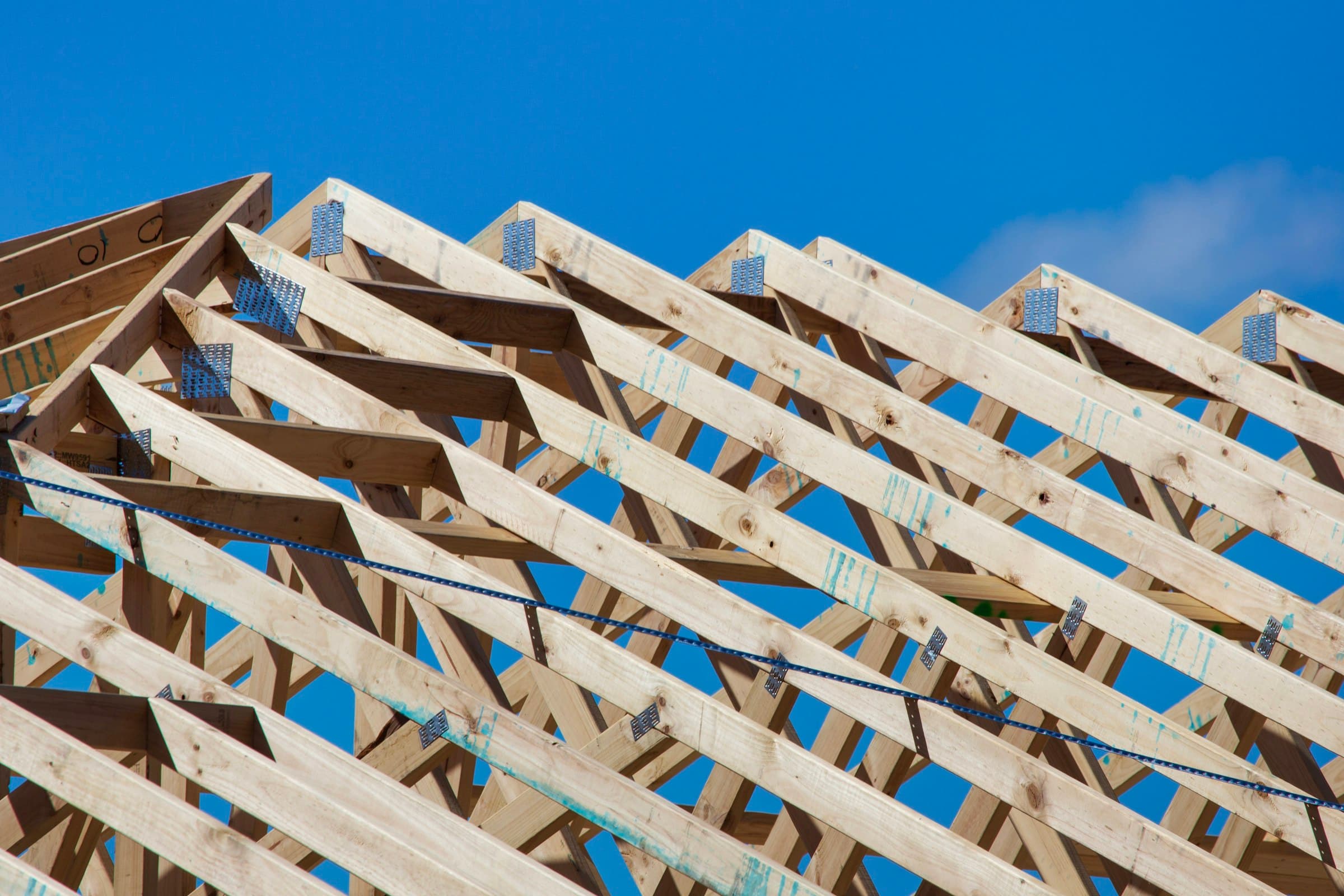 Timber framing of a house standing against an open sky.