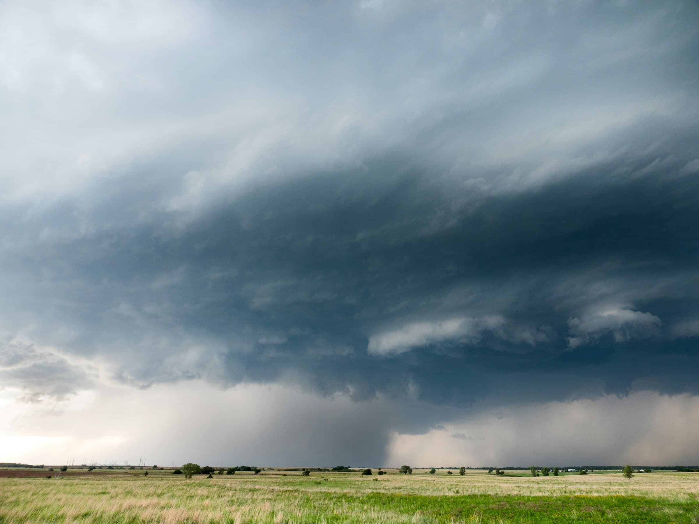 An open plain under a heavy grey storm sky.